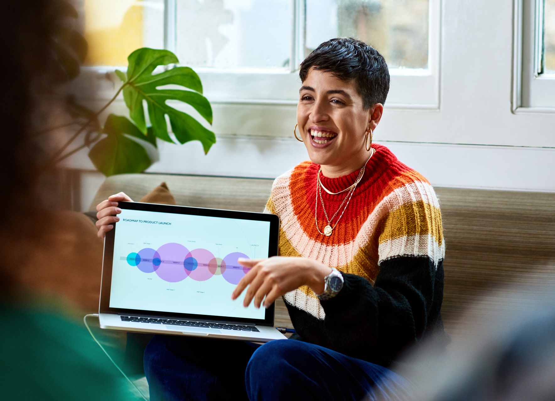 Digital skills bootcamps header showing a woman with dark hair and an orange stripy jumper holding a laptop and smiling